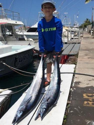 Boy shows his fish he caught while deep sea fishing